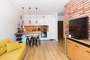 sala de estar con sofá y TV y cocina en City Center - Riverside by Apartmore en Gdansk