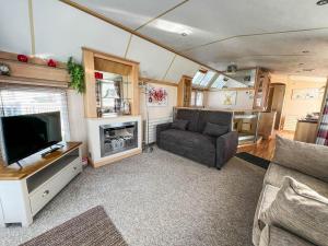 uma sala de estar com um sofá e uma televisão em Great Caravan For Hire With Pond Views At Manor Park Holiday Park Ref 23228k em Hunstanton