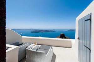 a private balcony with a view of the ocean at Kapari Natural Resort in Imerovigli