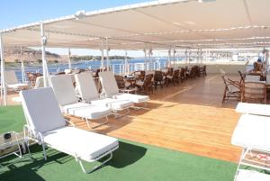 アスワンにあるNile Cruise Luxor Aswan 3,4 and 7 nightsの白い椅子とテーブルが備わるボートのデッキ