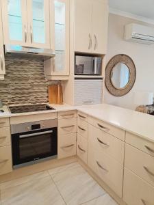 uma cozinha com armários brancos e um forno com placa de fogão em El Seuno de África -The dream of Africa em St. Lucia
