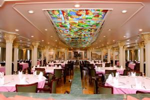 a dining room with tables and chairs and a stained glass ceiling at Nile Cruise Luxor Aswan 3,4 and 7 nights in Aswan