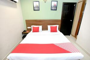 1 dormitorio con 1 cama con sábanas rojas y blancas en OYO Hotel Karma, en Jalandhar