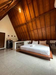 een groot bed in een kamer met een houten plafond bij Jepun homestay, gerupuk, pujut, lombok in Bumbang