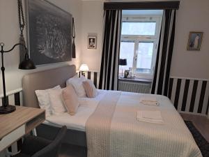 a bedroom with a bed and a desk and a window at Strand Hotel in Norrköping