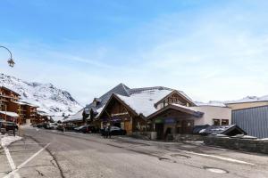 a ski lodge with snow covered mountains in the background at Résidence Machu Pichu - 3 Pièces pour 6 Personnes 244 in Val Thorens