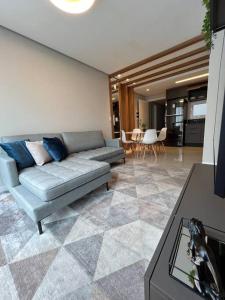 a living room with a couch and a table at Loft lindo de alto padrão in Capão da Canoa