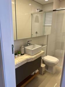 a bathroom with a sink and a toilet at Loft lindo de alto padrão in Capão da Canoa