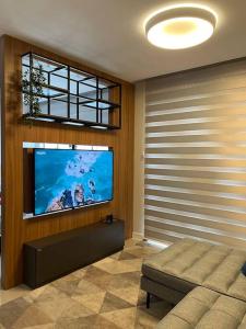 a living room with a flat screen tv on a wall at Loft lindo de alto padrão in Capão da Canoa