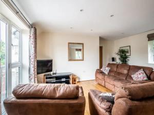 a living room with two brown couches and a tv at Spacious modern home in picturesque village in Exeter