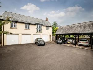 a garage with two cars parked in front of a house at Spacious modern home in picturesque village in Exeter