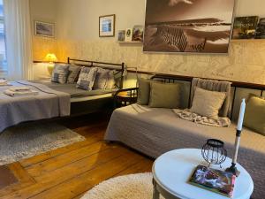 a bedroom with two beds and a table with a candle at Strand Hotel in Norrköping