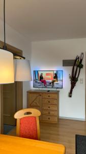 Zimmer mit einem Tisch und einem TV an der Wand in der Unterkunft Ferienhaus Ahorn in Neustift im Stubaital