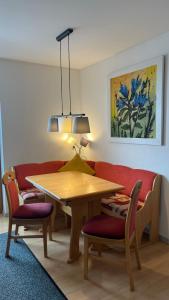 ein Esszimmer mit einem Tisch und einem roten Sofa in der Unterkunft Ferienhaus Ahorn in Neustift im Stubaital