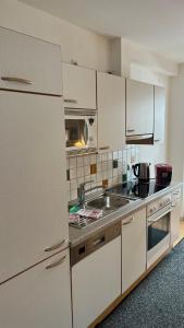 a kitchen with white cabinets and a sink at Ferienhaus Ahorn in Neustift im Stubaital