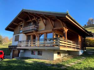 a large wooden house with a large balcony at Résidence Le Cristal - Chalets pour 8 Personnes 154 in Crest-Voland