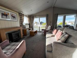 a living room with a couch and a fireplace at Beautiful Lodge With Decking In Hunstanton At Manor Park Ref 23195k in Hunstanton