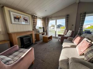 a living room with two couches and a fireplace at Beautiful Lodge With Decking In Hunstanton At Manor Park Ref 23195k in Hunstanton