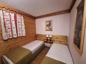 2 łóżka w niewielkim pokoju z drewnianymi ścianami w obiekcie Résidence Roselend - Charmant appartement de 3 pièces situé dans une résidence au village du Chantel, proche des pistes et avec piscine. MAE-2474 w mieście Arc 1800