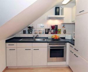 a white kitchen with a sink and a stove at Ferienwohnung Brigitte Leist in Sankt Wendel +2 photos