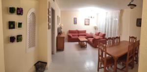 uma sala de estar com um sofá vermelho e uma mesa em APARTAMENTO PUERTO GOLF em Almerimar