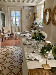 Locanda Sant' Agostino في لوكّا: غرفة معيشة مع طاولة طويلة عليها زهور