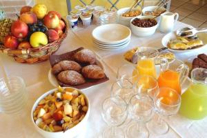 een tafel met fruitschalen en glazen sinaasappelsap bij Agriturismo il Porcellino in Quinto di Valpantena