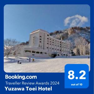 a hotel in the snow in front of a mountain at Yuzawa Toei Hotel in Yuzawa