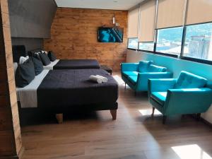 1 dormitorio con 1 cama y 2 sillas azules en Hotel Sonetto, en Santiago