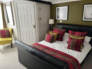 a bedroom with a bed with a black headboard and red pillows at The Ship Hotel in New Romney