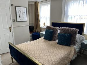 a bedroom with a bed with blue pillows on it at The Ship Hotel in New Romney
