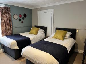 a bedroom with two beds and a window at The Ship Hotel in New Romney