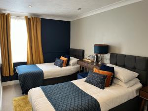 a hotel room with two beds and a couch at The Ship Hotel in New Romney