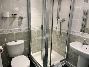 a bathroom with a shower and a toilet and a sink at The Ship Hotel in New Romney