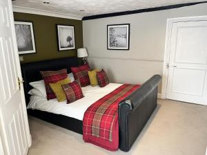 a bedroom with a bed with a plaid blanket at The Ship Hotel in New Romney