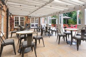 a patio with tables and chairs on a patio at The Ship Hotel in New Romney