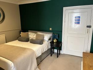 a bedroom with two beds and a green wall at The Ship Hotel in New Romney