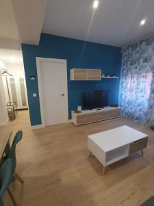 een woonkamer met een witte tafel en een blauwe muur bij Casa Elisa 2 in León