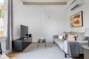 a living room with a couch and a tv at Blueground Sarrià nr Old Town BCN-103 in Barcelona