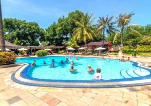 a group of people in a swimming pool at a resort at Suite Hotel Apartment Legian by RCP in Seminyak