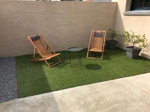 two chairs and a table on a patch of grass at L’atelier spa in Codognan