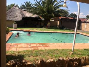 a person swimming in a swimming pool at Garden View Guesthouse Klinker in Johannesburg
