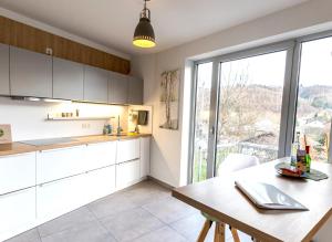 a kitchen with white cabinets and a table and a window at Femo SCHICK-modern, Natur, Rothaarsteig, 2Etg, 2Bäder in Burbach