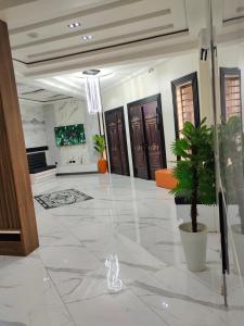 a lobby with doors and a potted plant on the floor at Passready Hotel and Suites Nnewi in Nnewi