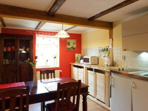 une cuisine aux murs rouges et une table en bois avec des chaises dans l'établissement Vacation holiday happiness, à Quedlinbourg 12 autres photos