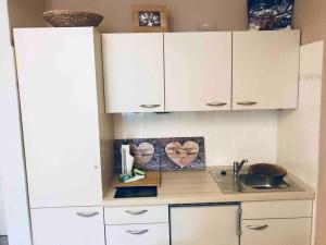 a kitchen with white cabinets and a sink at Ferienwohnung Darosa Gipfelglück in Seeg +24 photos