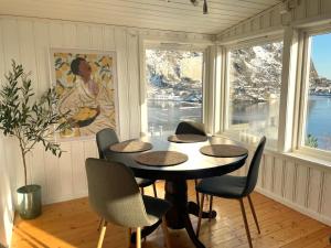 a dining room with a table and chairs and windows at Hytte i Svolvær in Svolvær