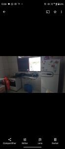 a picture of a kitchen with a microwave and a refrigerator at Casa em Cajupiranga temporada in Parnamirim