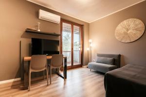 1 dormitorio con escritorio, 1 cama y 1 sofá en Mistral Apartments, en Puntone di Scarlino