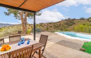 a table with fruit on it next to a swimming pool at Amazing Home In Sedella With House A Panoramic View in Sedella